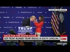 Woman inspects Donald Trump's hair on stage